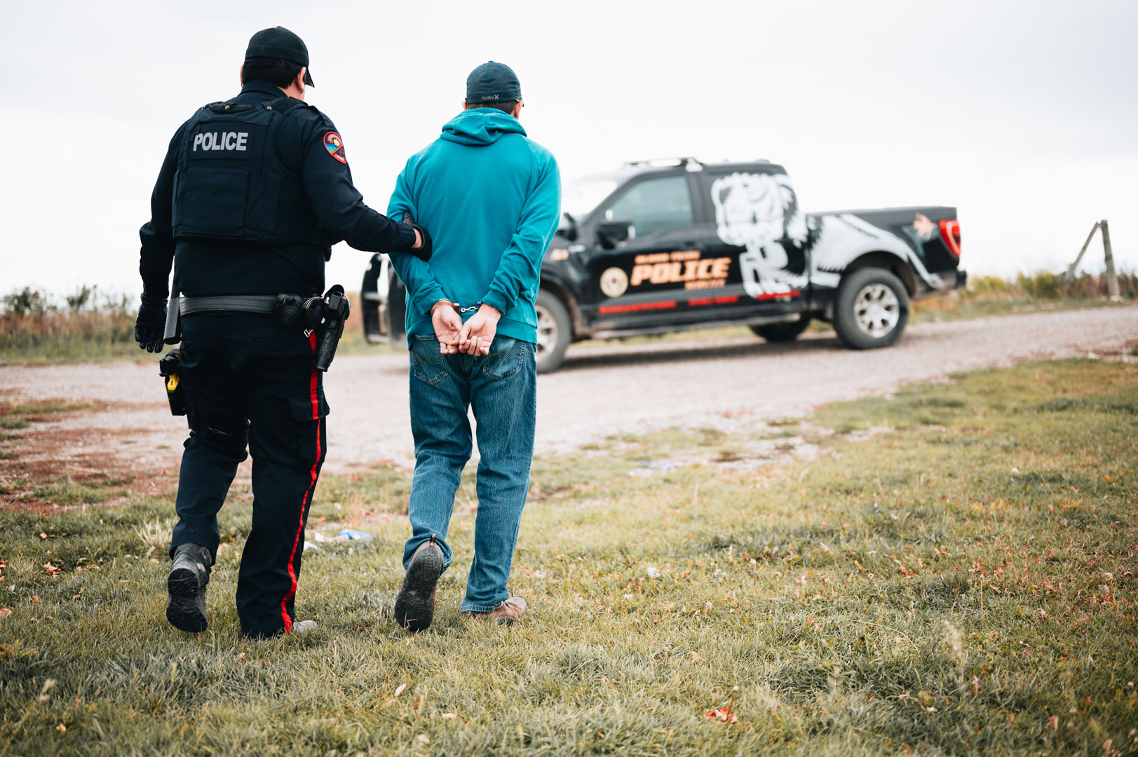 police officer and suspect walking to truck