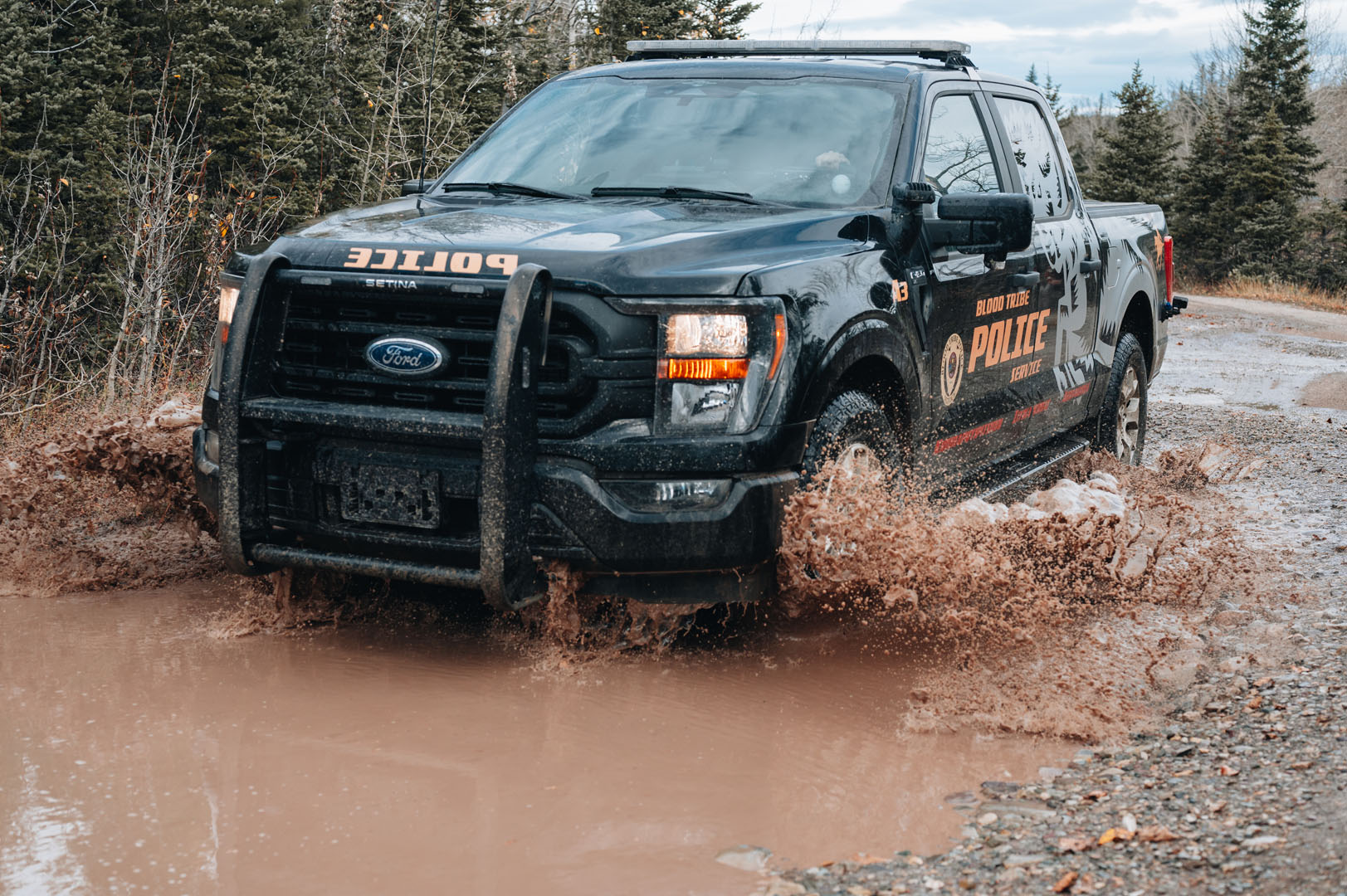 police truck driving through mud