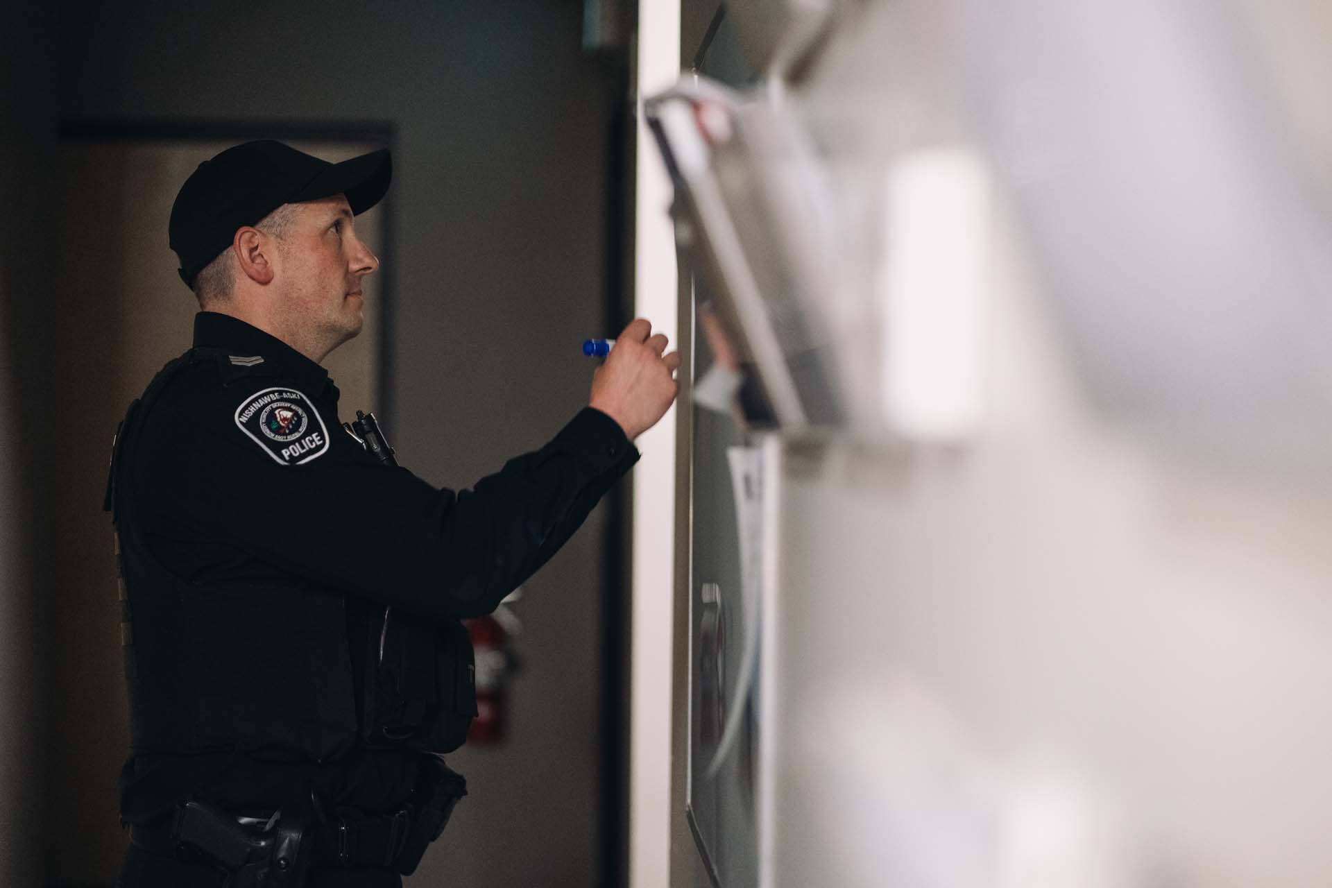 Nishnawbe Aski Police Service officer writing on a whiteboard